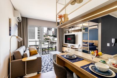 Sala integrada com cozinha americana e bancada — imagem para apartamentos de curta estadia